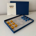 MorphMove tabletop game with board, blue and yellow marked dice, rulebook, and navy box